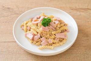 Spirali or spiral pasta mushroom cream sauce with ham - Italian food style photo