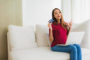 Portrait beautiful young asian women using computer laptop with mobile phone and credit card photo