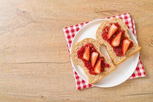 Homemade whole wheat bread with strawberry jam and fresh strawberry photo