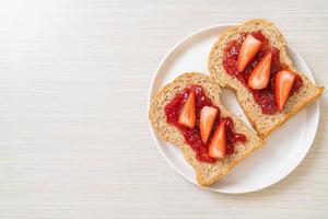 Homemade whole wheat bread with strawberry jam and fresh strawberry photo