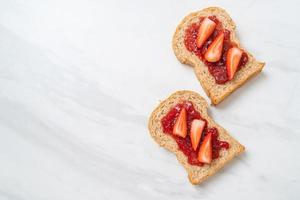 Homemade whole wheat bread with strawberry jam and fresh strawberry photo
