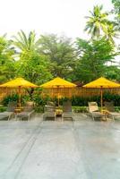 Umbrella and pool bed decoration around swimming pool in hotel resort photo