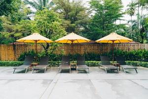 Umbrella and pool bed decoration around swimming pool in hotel resort photo