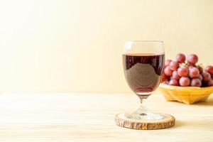 Fresh grape juice on wood background photo