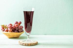 Fresh grape juice on wood background photo