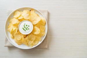 Potato chips with sour cream dipping sauce photo