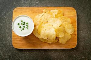 Potato chips with sour cream dipping sauce photo