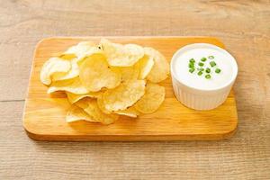 Potato chips with sour cream dipping sauce photo