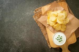 Potato chips with sour cream dipping sauce photo