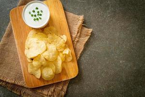 Potato chips with sour cream dipping sauce photo