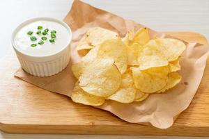 Potato chips with sour cream dipping sauce photo