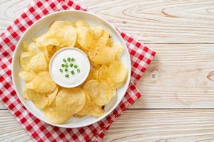 Potato chips with sour cream dipping sauce photo