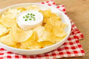 Potato chips with sour cream dipping sauce photo