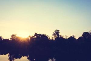 hermoso paisaje de río y puesta de sol foto