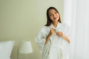 retrato, hermoso, joven, mujeres asiáticas, con, taza de café, en, dormitorio foto