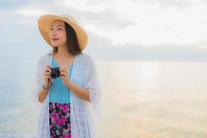 retrato, hermoso, joven, mujeres asiáticas, feliz, sonrisa, relajarse, alrededor, mar, playa, océano foto