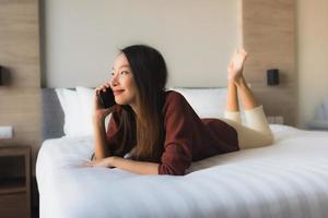 Portrait beautiful young asian women using mobile phone on bed photo