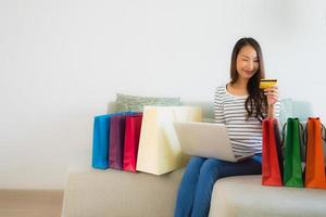 Retrato de hermosas mujeres asiáticas jóvenes con tarjeta de crédito, teléfono móvil o computadora para ir de compras foto