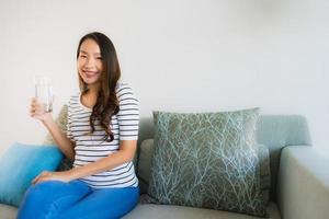 Portrait beautiful young asian women holding drink water glass on sofa photo