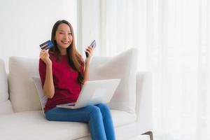 retrato, hermoso, joven, mujeres asiáticas, utilizar, computadora portátil, con, teléfono móvil, y, tarjeta de crédito foto