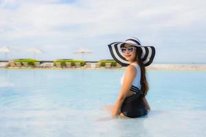 retrato, hermoso, joven, mujeres asiáticas, feliz, sonrisa, relajarse, alrededor, piscina foto