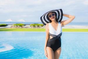 retrato, hermoso, joven, mujeres asiáticas, feliz, sonrisa, relajarse, alrededor, piscina foto