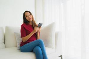 Portrait beautiful young asian women using mobile or smart phone on sofa photo