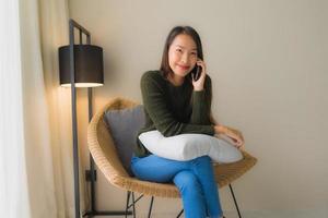 Portrait beautiful young asian women using talking mobile phone and sitting on sofa chair photo
