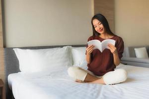 retrato, hermoso, joven, mujeres asiáticas, libro de lectura, en cama foto