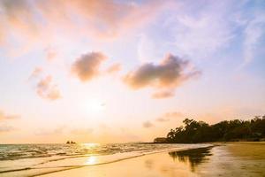 hermosa puesta de sol en la playa y el mar foto