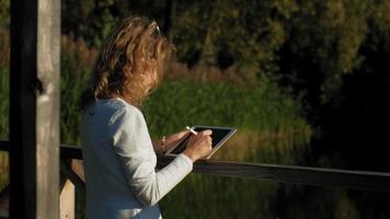 mujer está usando una tableta de computadora al aire libre