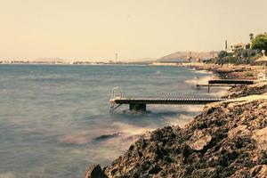 playa de alcanada con puertos de madera con vistas al puerto de alcudia. mar enfurecido contra el puerto de madera foto