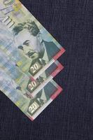 Israeli banknotes of twenty shekels between blue denim fabric photo