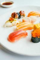 Sushi nigiri crudo y fresco en placa blanca.