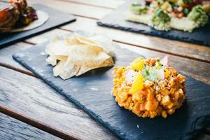 Raw fresh salmon meat tartare in black plate photo