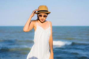 Portrait beautiful young asian woman happy smile relax around neary beach and sea photo