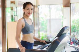 Retrato hermosa joven mujer asiática ejercicio con aparatos de gimnasia en el interior del gimnasio foto