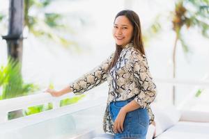 Portrait beautiful young asian woman happy and smile with travel in hotel resort neary sea and beach photo