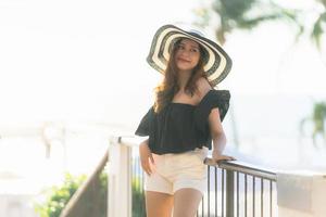 Portrait beautiful young asian woman happy and smile with travel in hotel resort neary sea and beach photo