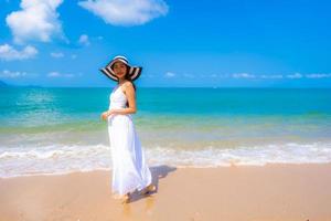 Portrait beautiful young asian woman happy smile leisure on the beach sea and ocean photo