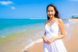 Portrait beautiful young asian woman happy smile leisure on the beach sea and ocean photo