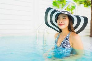 retrato, hermoso, joven, mujer asiática, feliz, sonrisa, relajarse, alrededor, piscina exterior foto