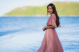 Portrait young beautiful asian woman walk smile and happy on the beach sea and ocean photo