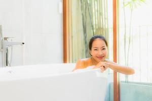 Retrato joven bella mujer asiática tomar un baño en la bañera. foto