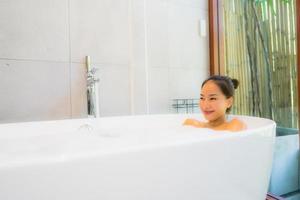 Portrait young beautiful asian woman take a bath in bathtub photo