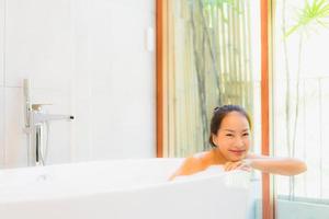 Retrato joven bella mujer asiática tomar un baño en la bañera. foto