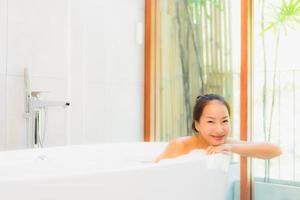 Retrato joven bella mujer asiática tomar un baño en la bañera. foto