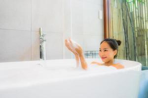 Retrato joven bella mujer asiática tomar un baño en la bañera. foto