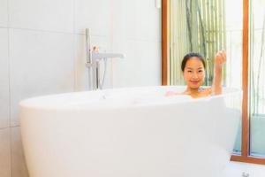 Retrato joven bella mujer asiática tomar un baño en la bañera. foto