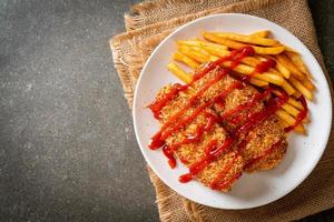 Filete de pechuga de pollo frito con papas fritas y salsa de tomate foto